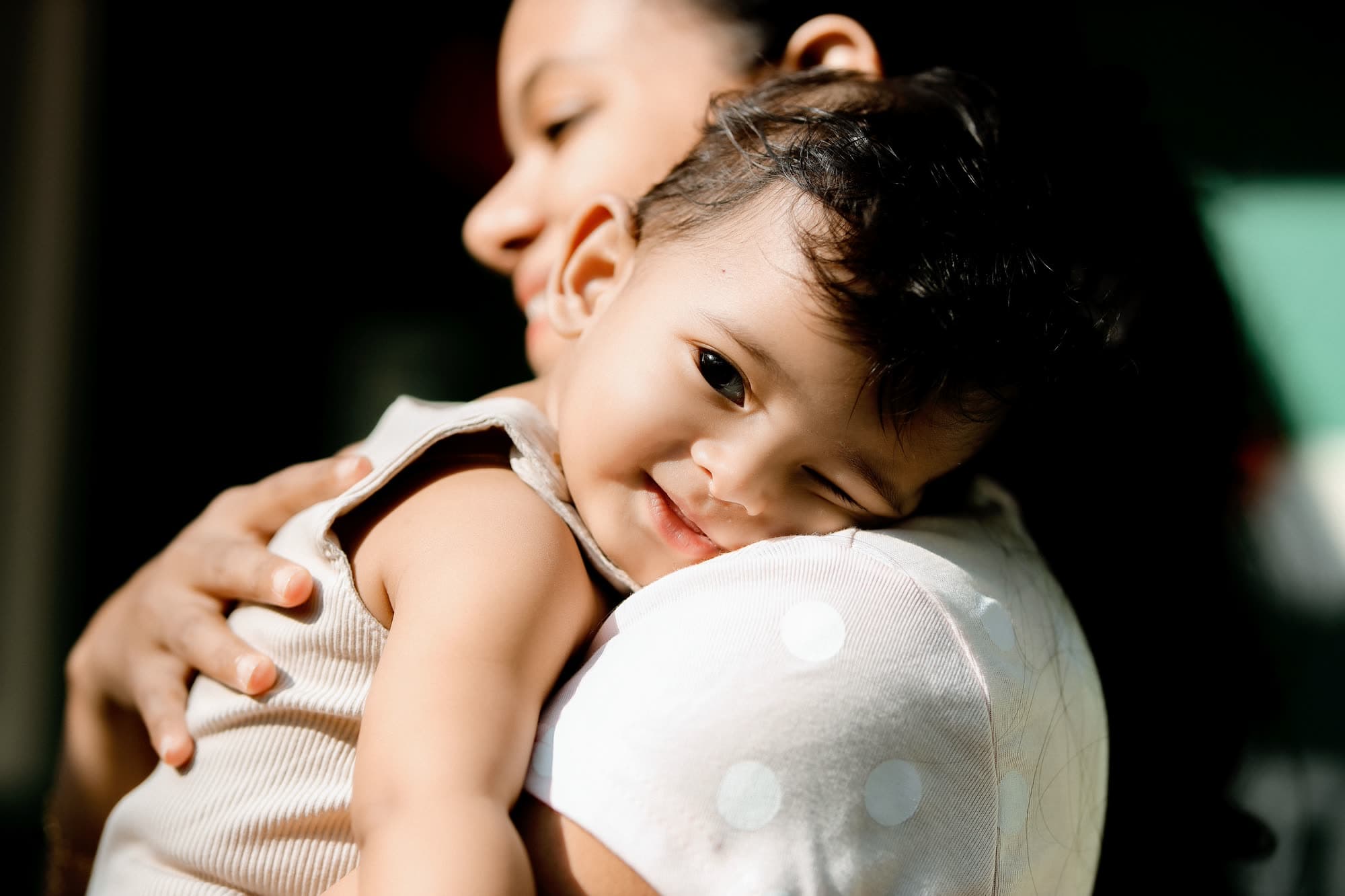 A caregiver holding a calm, sleepy child