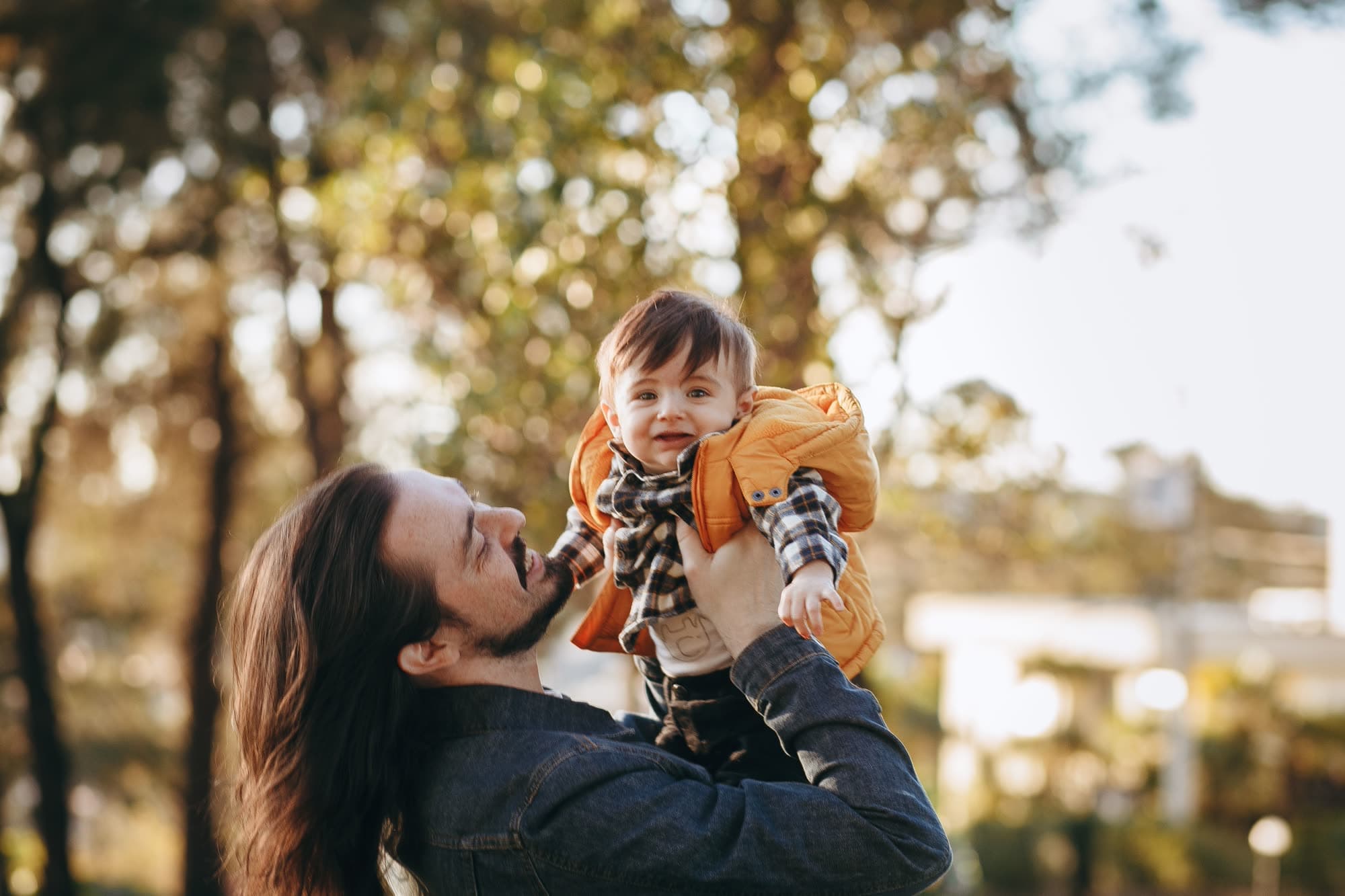 A parent joyfully lifting their child in the air